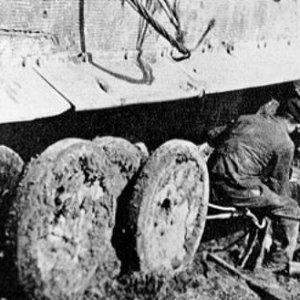 Fitters working on a Tiger's suspension in the mud. Notice how it congeals around the road wheels and imagine the difficulties of handling heavy compo